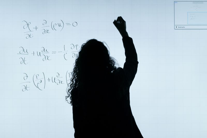 Compresor metálico con conexiones y etiqueta técnica sobre superficie clara